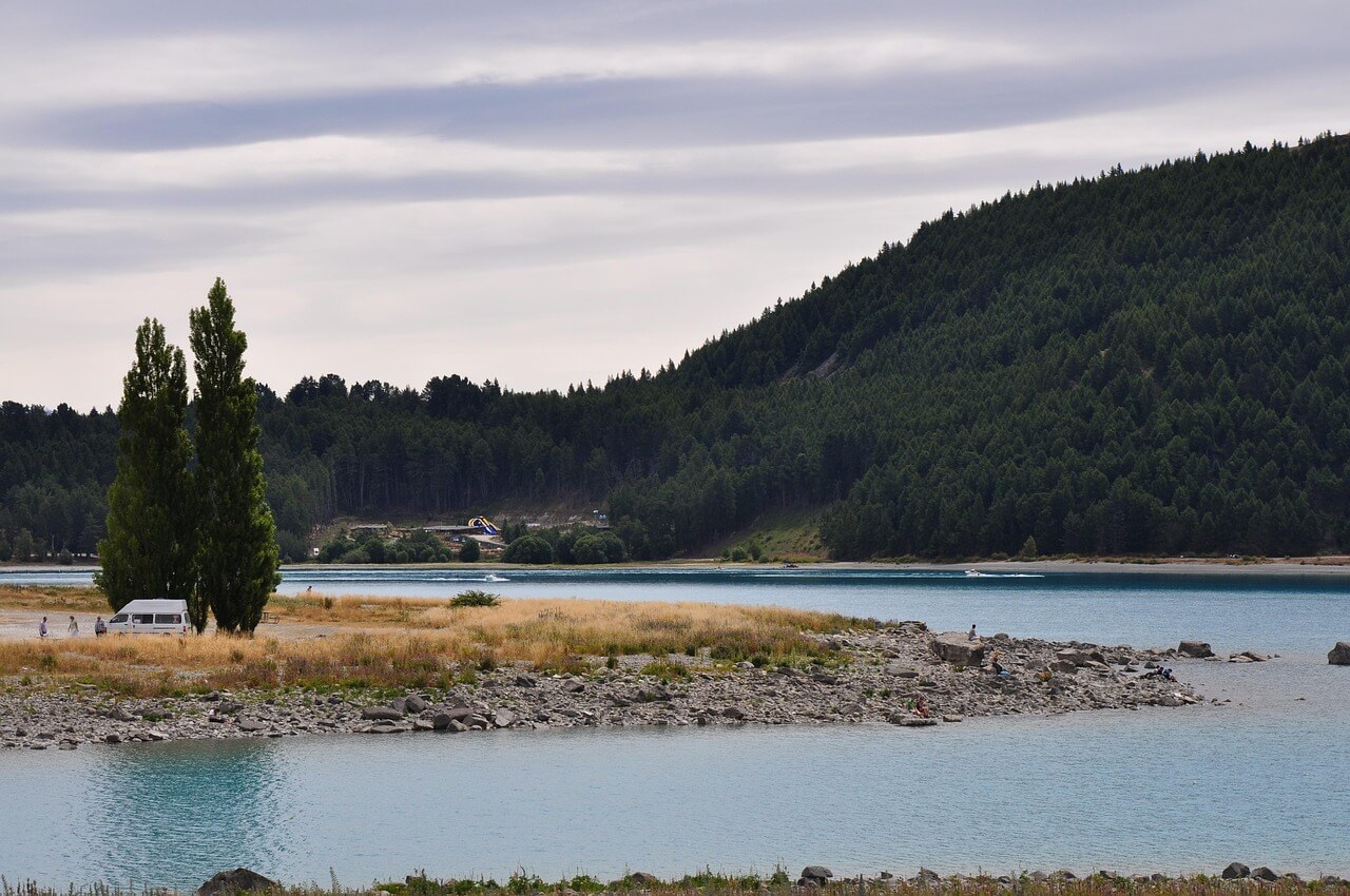 Van aménagé près d’un lac et de montagnes en Nouvelle-Zélande